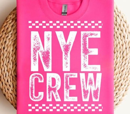 Pink t-shirt with 'NYE CREW' text on a woven surface