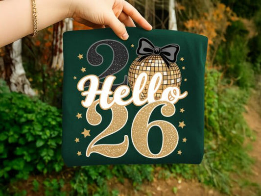 Green bag with 'Hello 26' design held by a hand outdoors