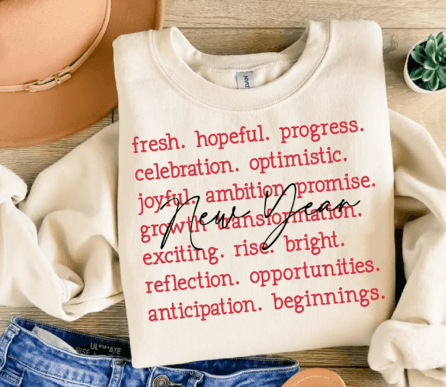 White sweatshirt with red text on a wooden surface