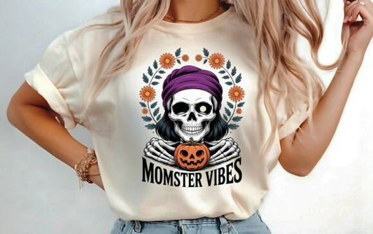 Halloween Momster Vibes T-shirt with skeleton mom, purple headwrap, jack-o’-lantern, and floral wreath design