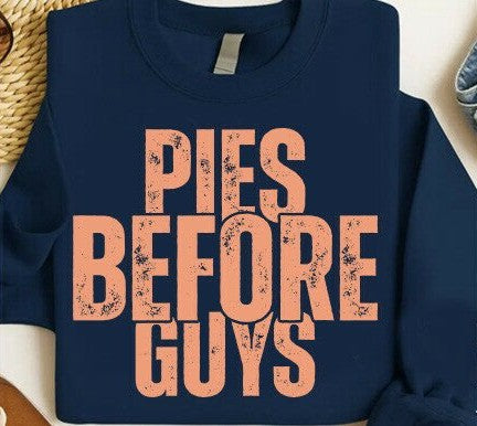 Navy blue sweatshirt with 'PIES BEFORE GUYS' text in pink on a textured surface.